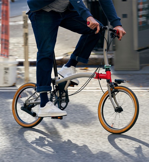 A cyclist rides a Brompton CHPT3 on city streets